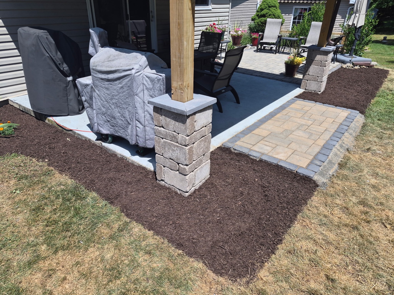 Paver patio with stone column and landscape construction in Schuylkill County PA